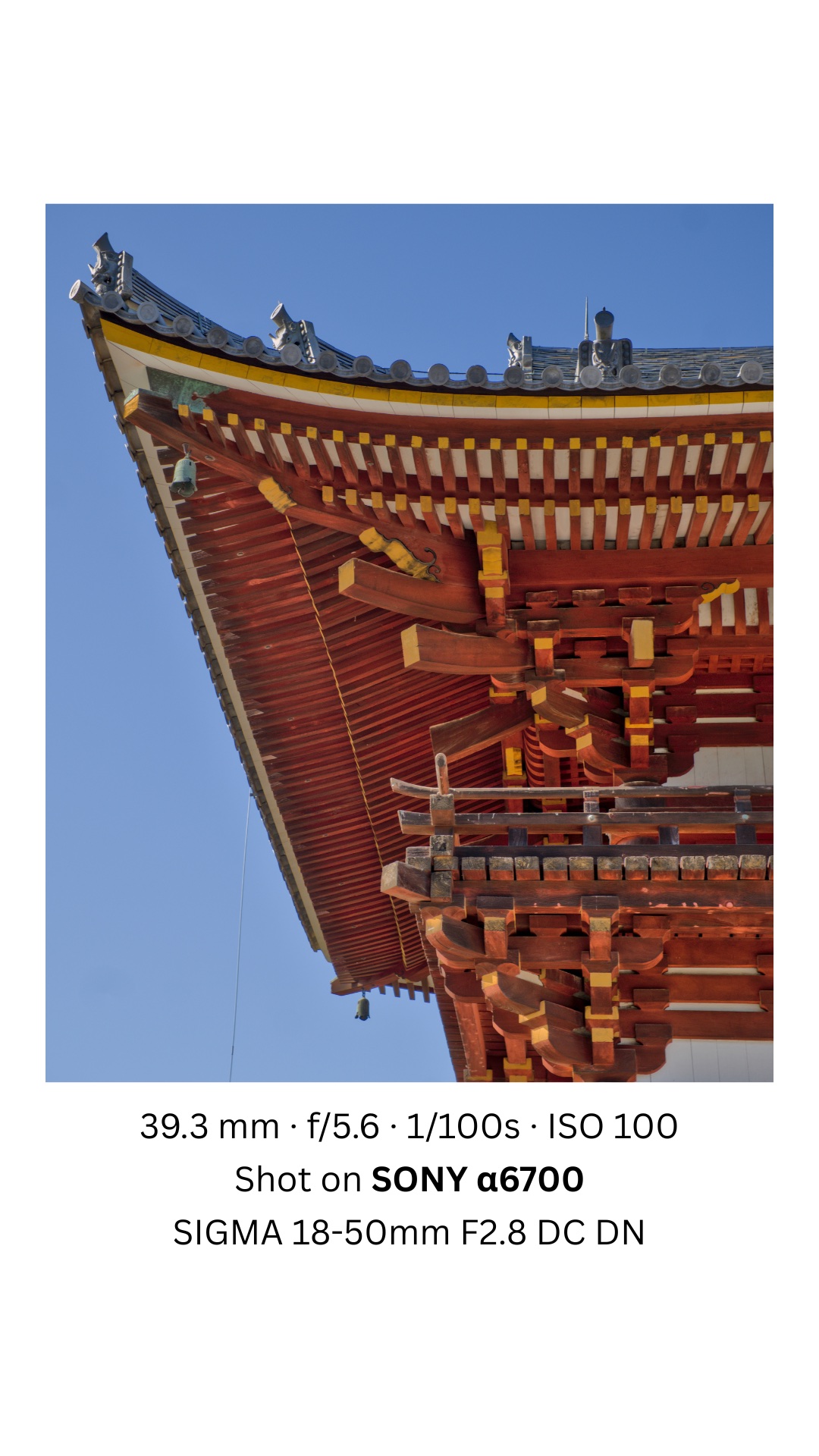 Upturned temple roof and bracket work against a clear sky